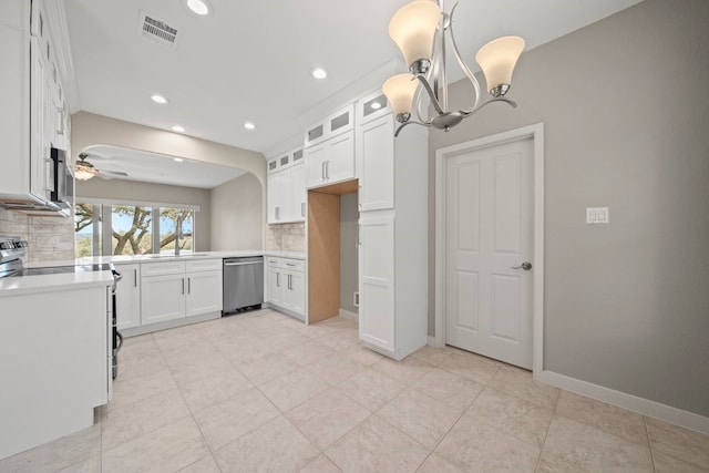 kitchen with ceiling fan with notable chandelier, stainless steel appliances, white cabinets, hanging light fixtures, and tasteful backsplash