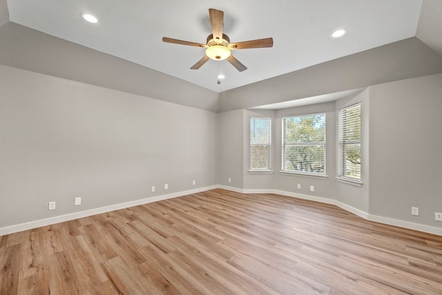 spare room featuring ceiling fan, light wood-type flooring, and vaulted ceiling