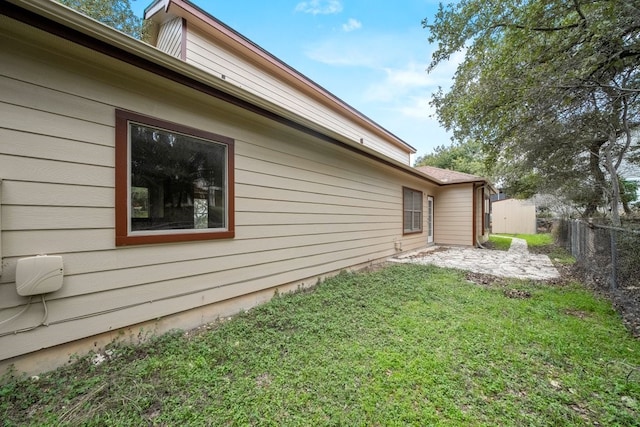 view of side of property featuring a patio and a yard