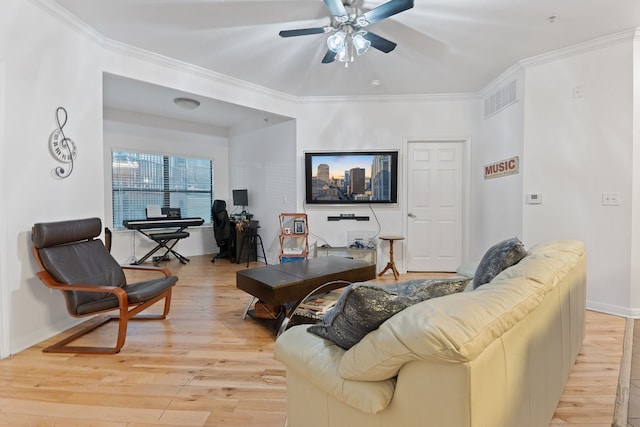 living room with ornamental molding, light hardwood / wood-style floors, and ceiling fan