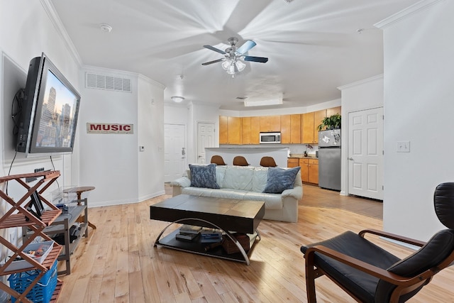 living room with sink, light hardwood / wood-style flooring, ornamental molding, and ceiling fan