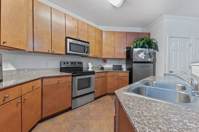 kitchen with crown molding, appliances with stainless steel finishes, sink, and light stone counters