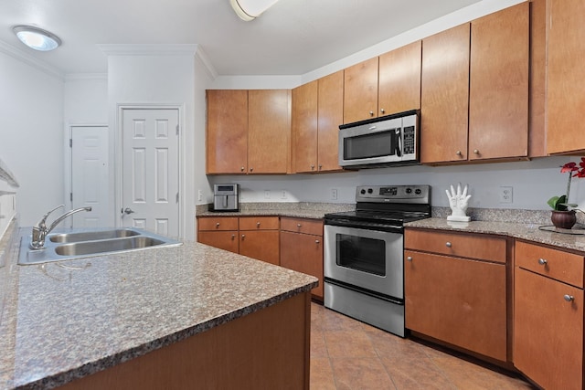 kitchen featuring sink, light tile patterned floors, ornamental molding, and appliances with stainless steel finishes