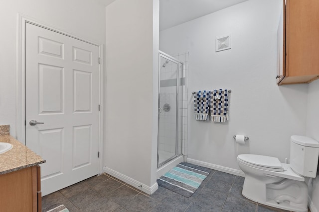 bathroom with vanity, a shower with shower door, and toilet