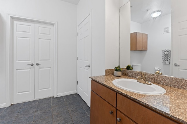 bathroom featuring vanity, toilet, and tile patterned flooring