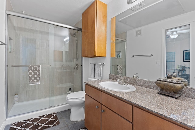 bathroom with tile patterned flooring, walk in shower, vanity, and toilet