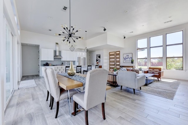 dining room with light hardwood / wood-style floors and a notable chandelier