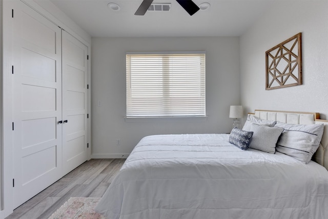 bedroom featuring ceiling fan, a closet, and light wood-type flooring