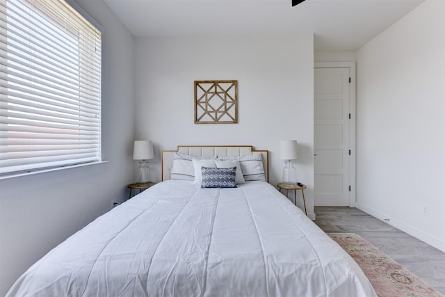 bedroom with multiple windows and light hardwood / wood-style flooring