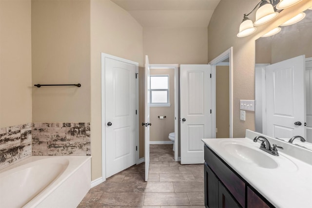 bathroom with toilet, a bath, tile patterned flooring, vaulted ceiling, and vanity