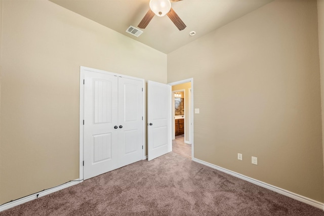 unfurnished bedroom featuring light carpet, ceiling fan, and a closet