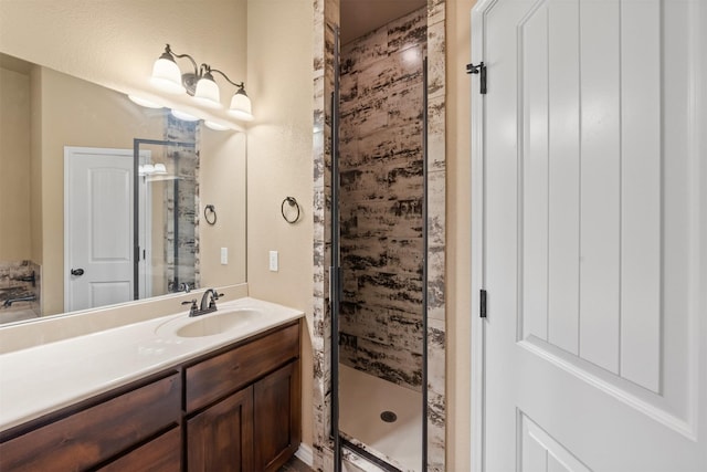 bathroom with a shower with shower door and vanity