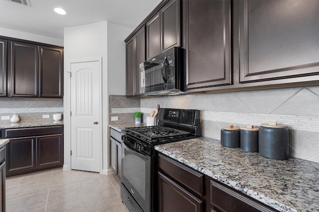 kitchen featuring light stone countertops, light tile patterned floors, backsplash, and black appliances