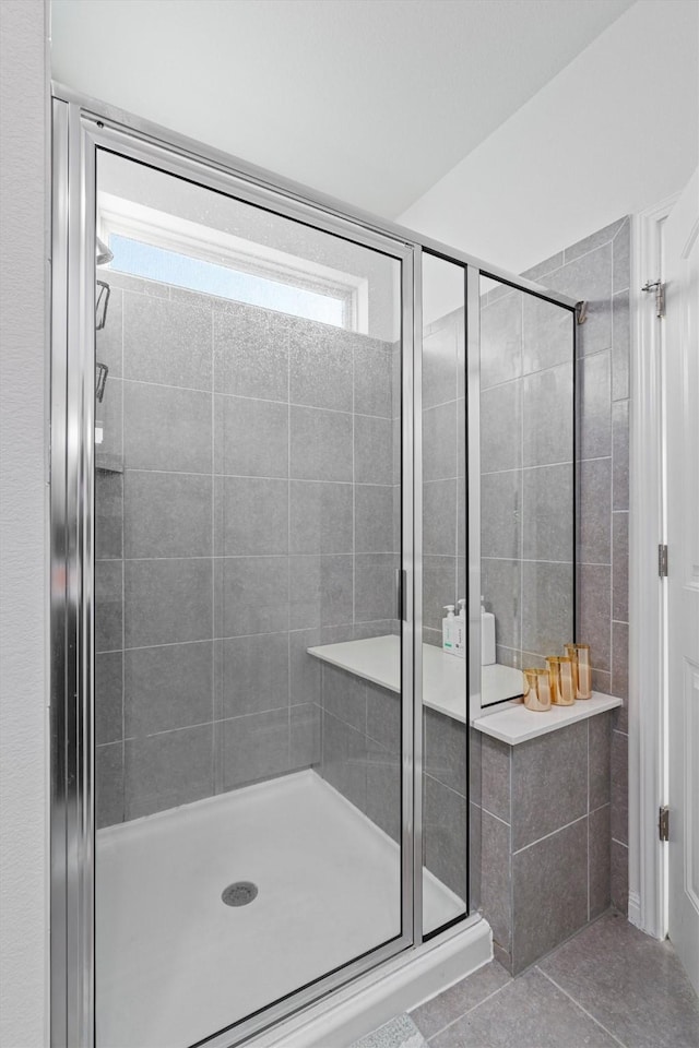 bathroom featuring a shower with shower door and tile patterned floors