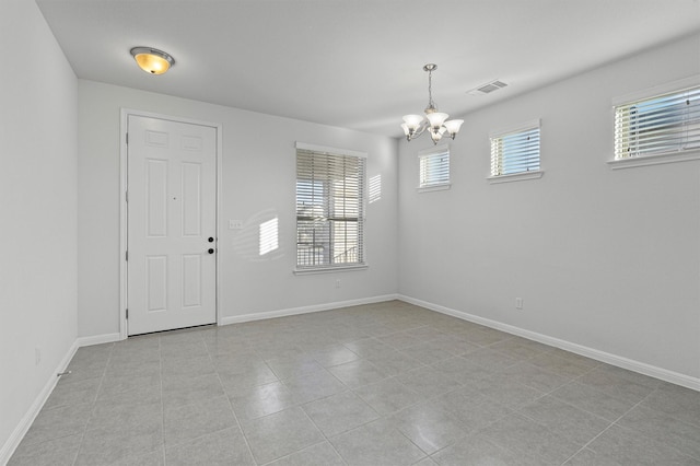 entrance foyer with light tile patterned floors and a chandelier