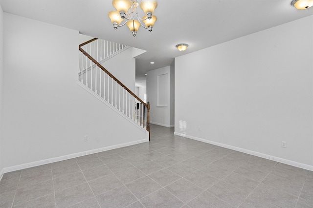 spare room featuring a chandelier and light tile patterned flooring