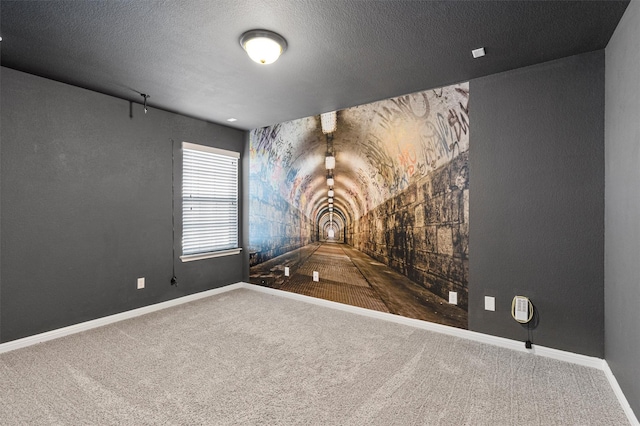 carpeted empty room with a textured ceiling