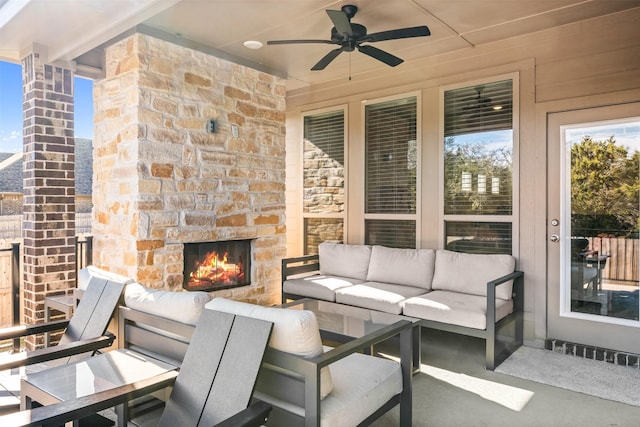 view of patio with an outdoor living space with a fireplace and a ceiling fan