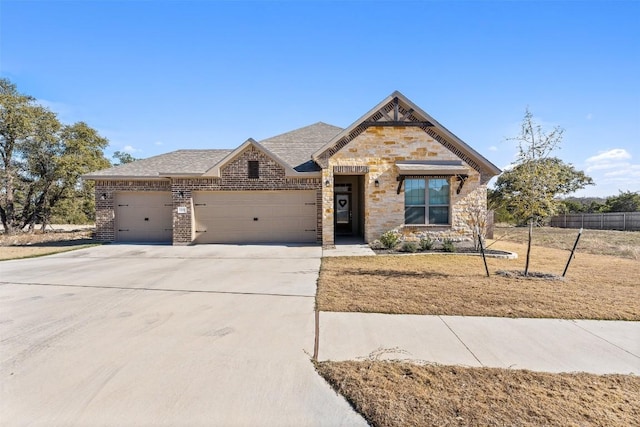 1207 Haley Ln, Salado, TX 76571 - view of front of house featuring a garage, concrete driveway, stone siding, and brick siding