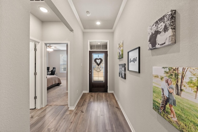 foyer featuring baseboards, ornamental molding, and wood finished floors