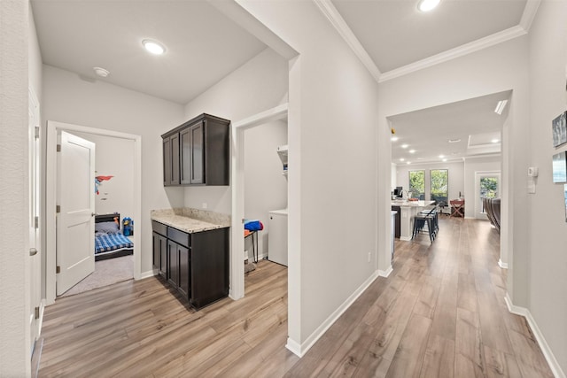 hallway featuring light wood-style floors, baseboards, ornamental molding, and recessed lighting