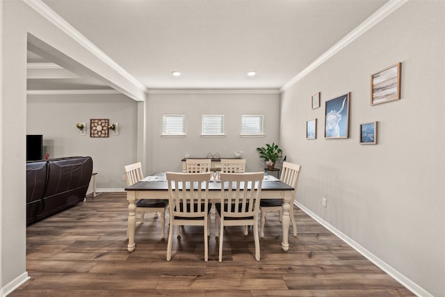 dining space with crown molding, baseboards, and wood finished floors