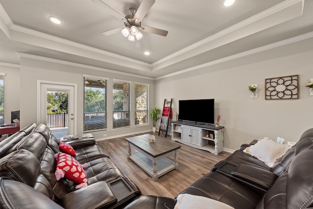 living area featuring ceiling fan, a raised ceiling, crown molding, and wood finished floors