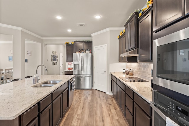 kitchen with light wood finished floors, visible vents, stainless steel appliances, under cabinet range hood, and a sink