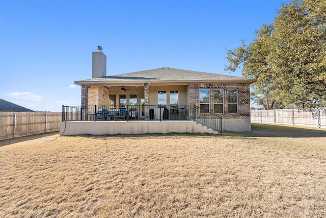 1207 Haley Ln, Salado, TX 76571 - back of property featuring a ceiling fan, a chimney, a fenced backyard, and brick siding