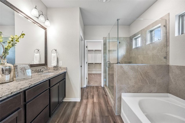 1207 Haley Ln, Salado, TX 76571 - full bathroom with a stall shower, a garden tub, vanity, wood finished floors, and a spacious closet