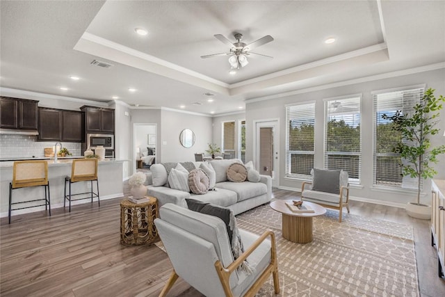 1207 Haley Ln, Salado, TX 76571 - living room featuring a raised ceiling, light wood-style floors, ceiling fan, ornamental molding, and recessed lighting