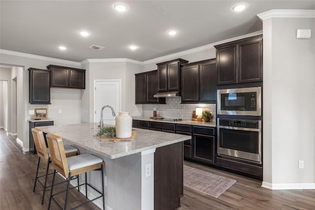 1207 Haley Ln, Salado, TX 76571 - kitchen with stainless steel appliances, tasteful backsplash, dark brown cabinetry, dark wood-type flooring, and ornamental molding