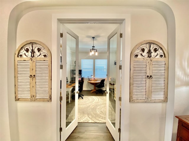 hallway with wood-type flooring and french doors