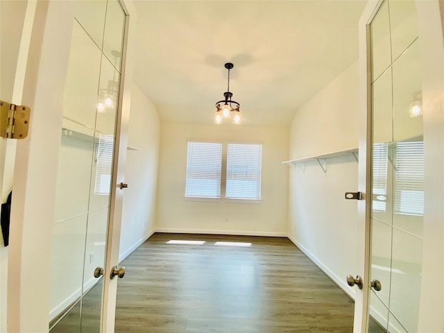 bathroom featuring hardwood / wood-style flooring, french doors, and an inviting chandelier