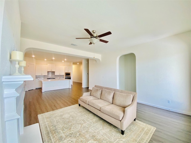 living room with ceiling fan and light wood-type flooring