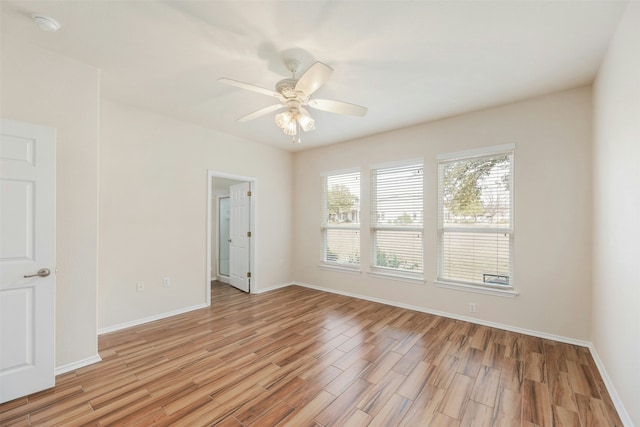 empty room with ceiling fan and light hardwood / wood-style flooring