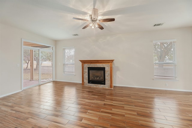 unfurnished living room featuring ceiling fan and a fireplace