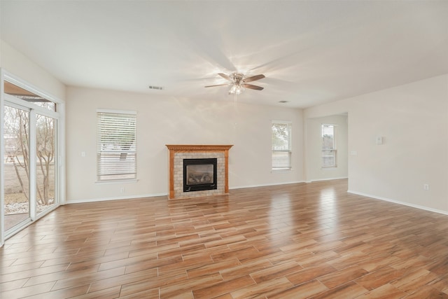 unfurnished living room with ceiling fan and a fireplace