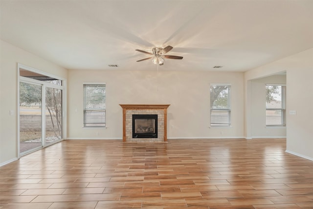 unfurnished living room with ceiling fan and a tile fireplace