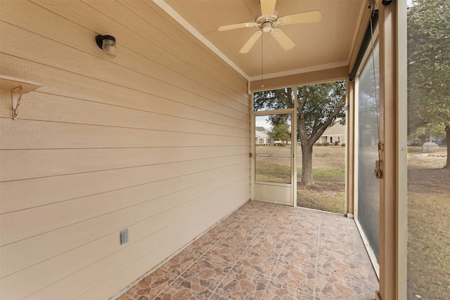 unfurnished sunroom with ceiling fan