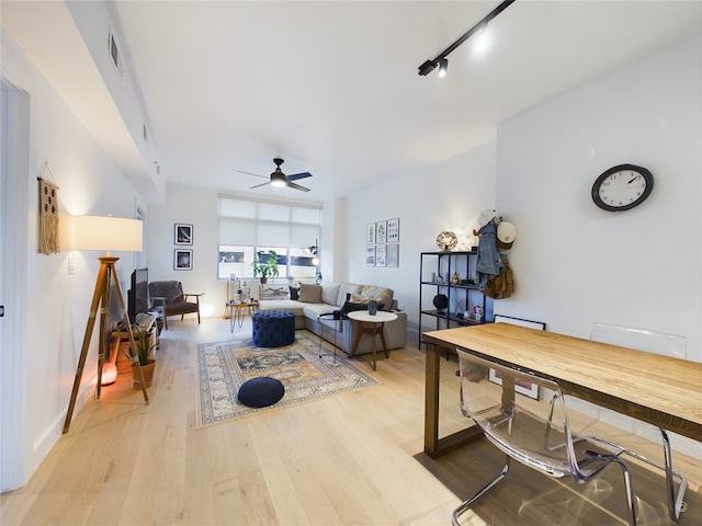 living room featuring ceiling fan, rail lighting, and light hardwood / wood-style flooring