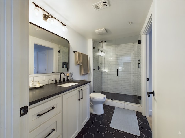 bathroom with toilet, vanity, an enclosed shower, and tile patterned floors