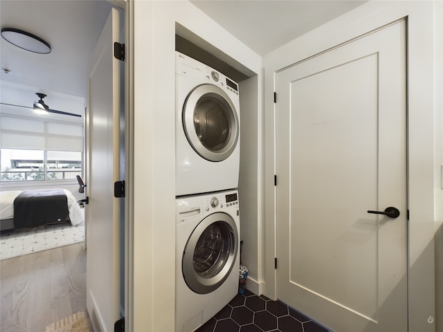 laundry room with stacked washer and dryer, ceiling fan, and dark hardwood / wood-style floors