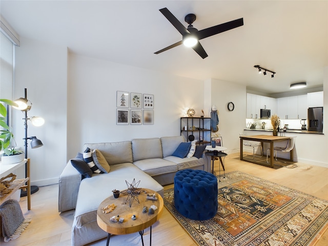 living room featuring light hardwood / wood-style floors, track lighting, and ceiling fan