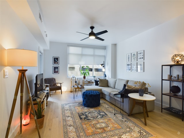 living room with ceiling fan and light hardwood / wood-style flooring