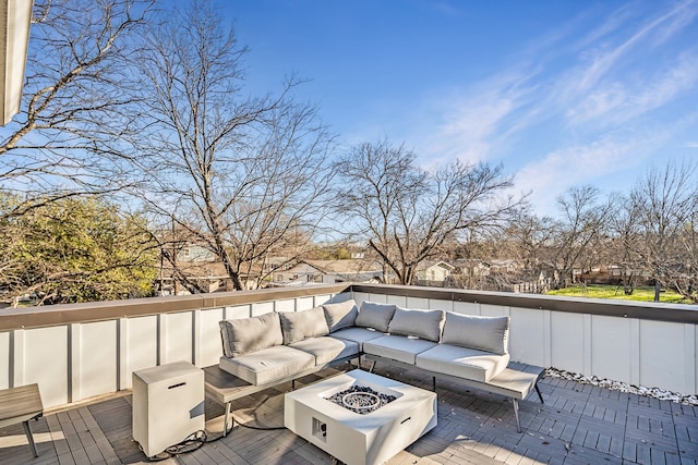 wooden terrace with an outdoor living space with a fire pit