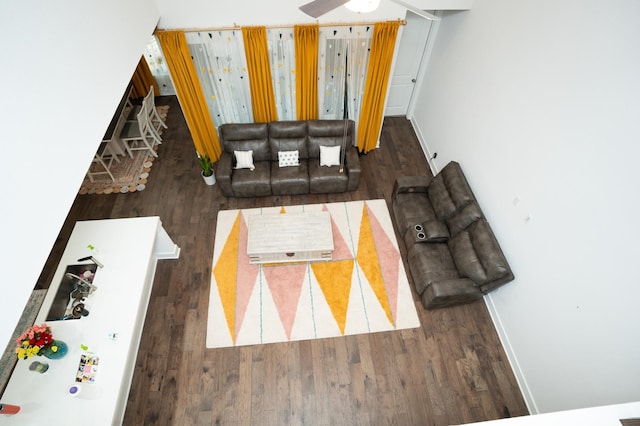 living room with ceiling fan and dark hardwood / wood-style flooring