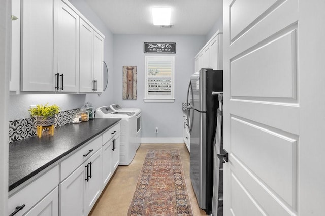 clothes washing area with cabinets and separate washer and dryer