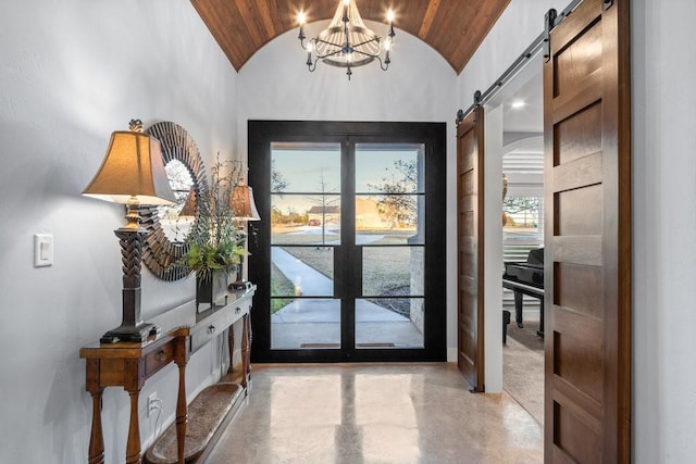 foyer entrance with brick ceiling, vaulted ceiling, a chandelier, and a barn door