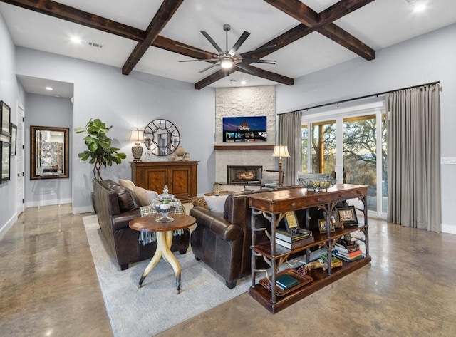 living room featuring ceiling fan, beamed ceiling, a stone fireplace, and coffered ceiling